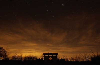 Stars and light on horizon over a dusk sky